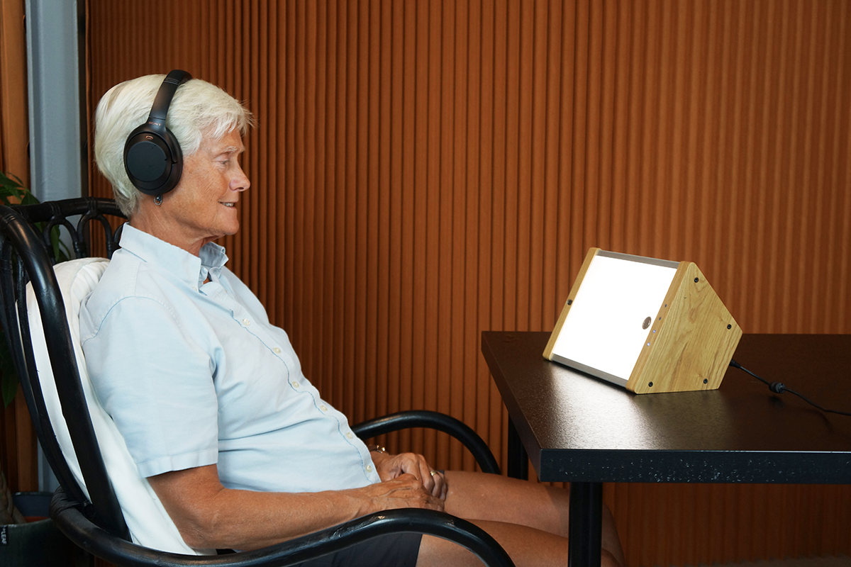 Older woman using EVY LIGHT while listening to music
