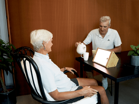 Older couple using EVY LIGHT while having a cup of tea