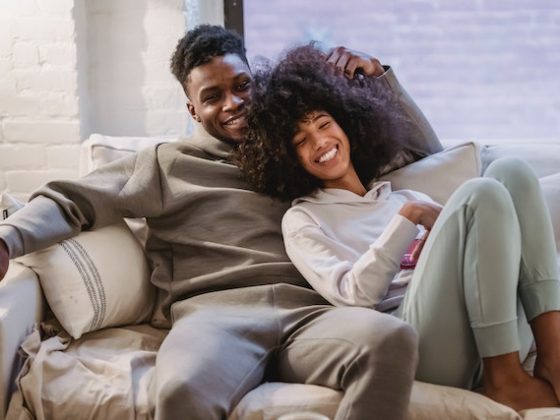 Young Couple laughing while relaxing on the couch