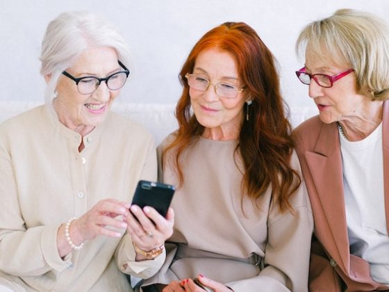older women looking at phone and laughing together