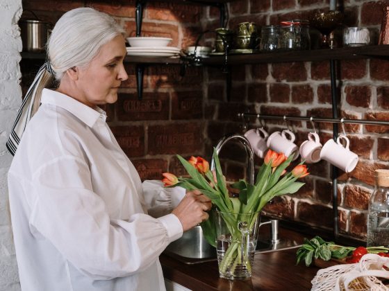older woman arranging flowers in her house